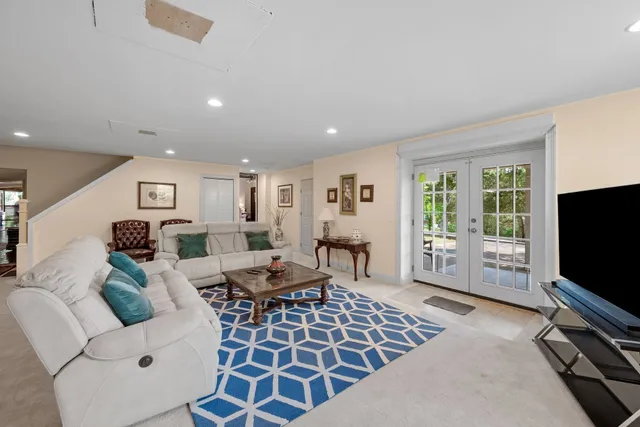 a living room with furniture a flat screen tv and a window