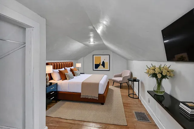 a spacious bedroom with a bed and a flat screen tv