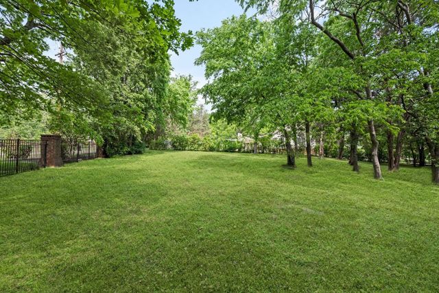 a view of green field with trees in the background