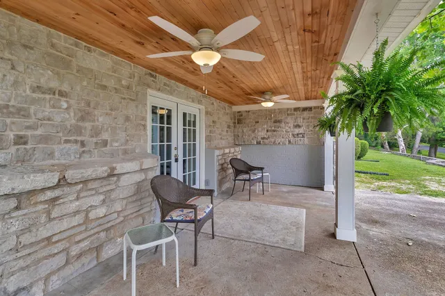 a view of a patio with a table and chairs and potted plants
