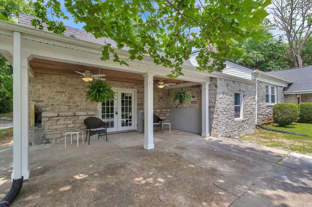 a view of a chair and table in backyard of the house