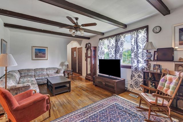 a living room with furniture a flat screen tv and a large window