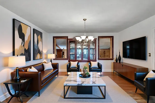 a living room with furniture flat screen tv and large windows