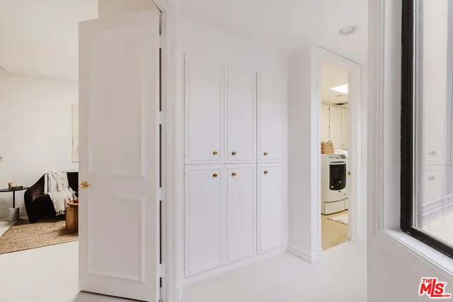 a view of a hallway with closet and mirror