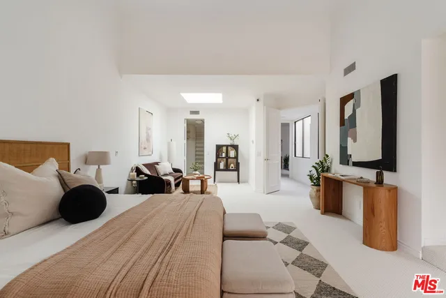 a large bedroom with a bed and large mirror