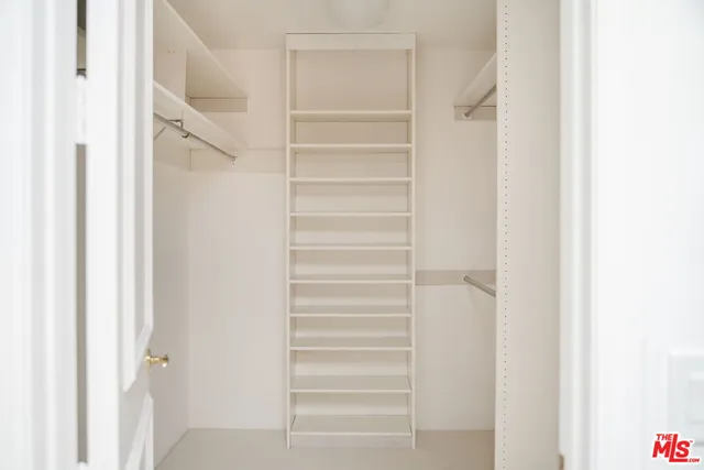 a view of walk in closet with empty racks