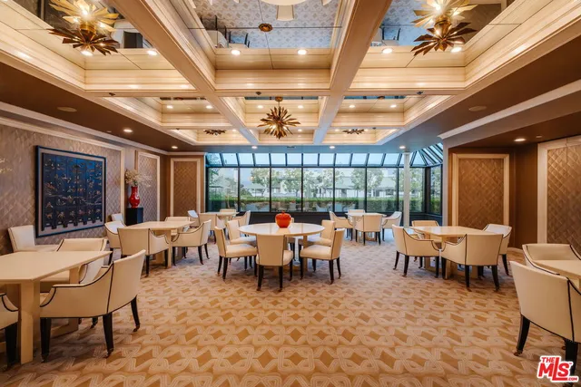 a room with lots of tables a large window and furniture