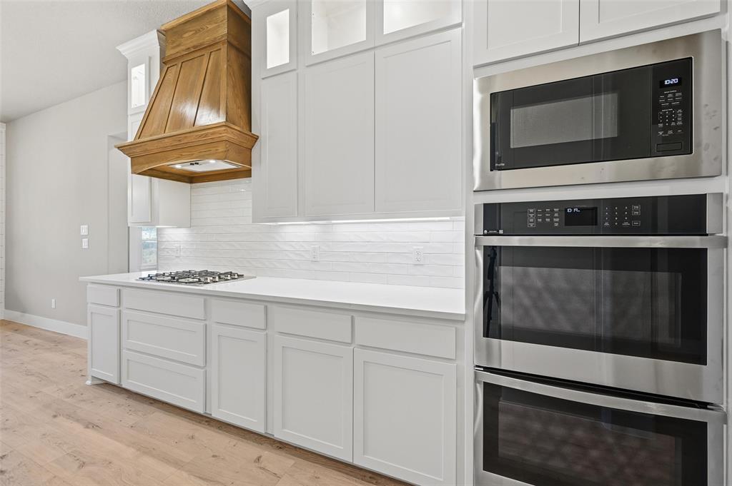 1053 Llano Way Poolville, TX 76487 - Photo 19 of 40 a kitchen with granite countertop cabinets stainless steel appliances and a stove