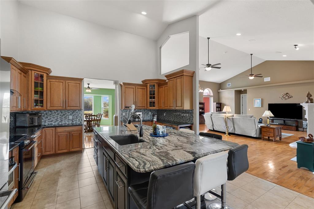 29336 Sam Way Punta Gorda, FL 33982 - Photo 7 of 44 a kitchen with kitchen island granite countertop a stove and a sink