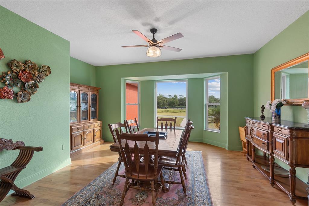 29336 Sam Way Punta Gorda, FL 33982 - Photo 10 of 44 a dining room with furniture a potted plant and wooden floor