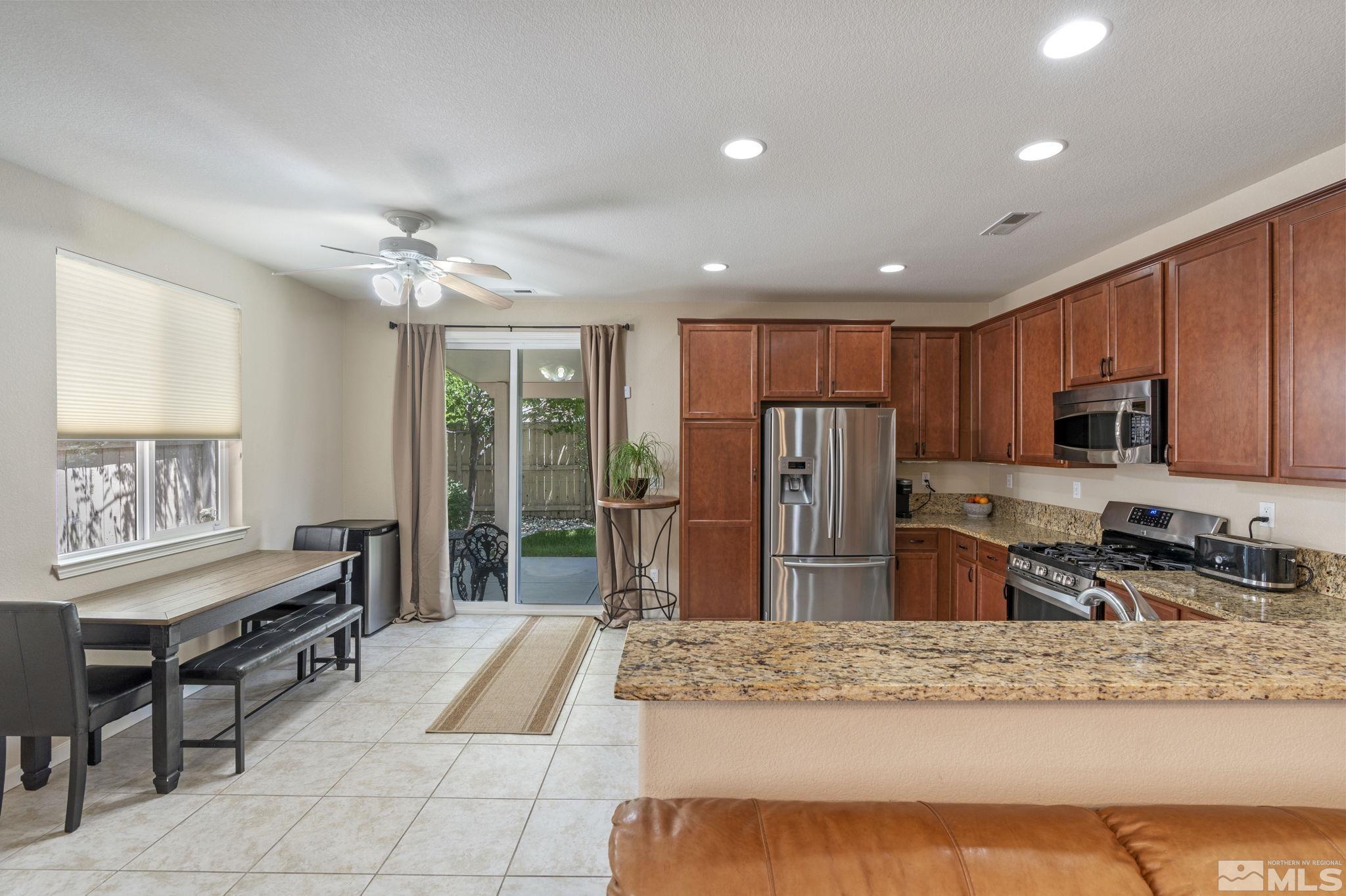 10848 Oakhaven Drive Reno, NV 89521 - Photo 12 of 32 a kitchen with stainless steel appliances granite countertop a refrigerator stove microwave and sink