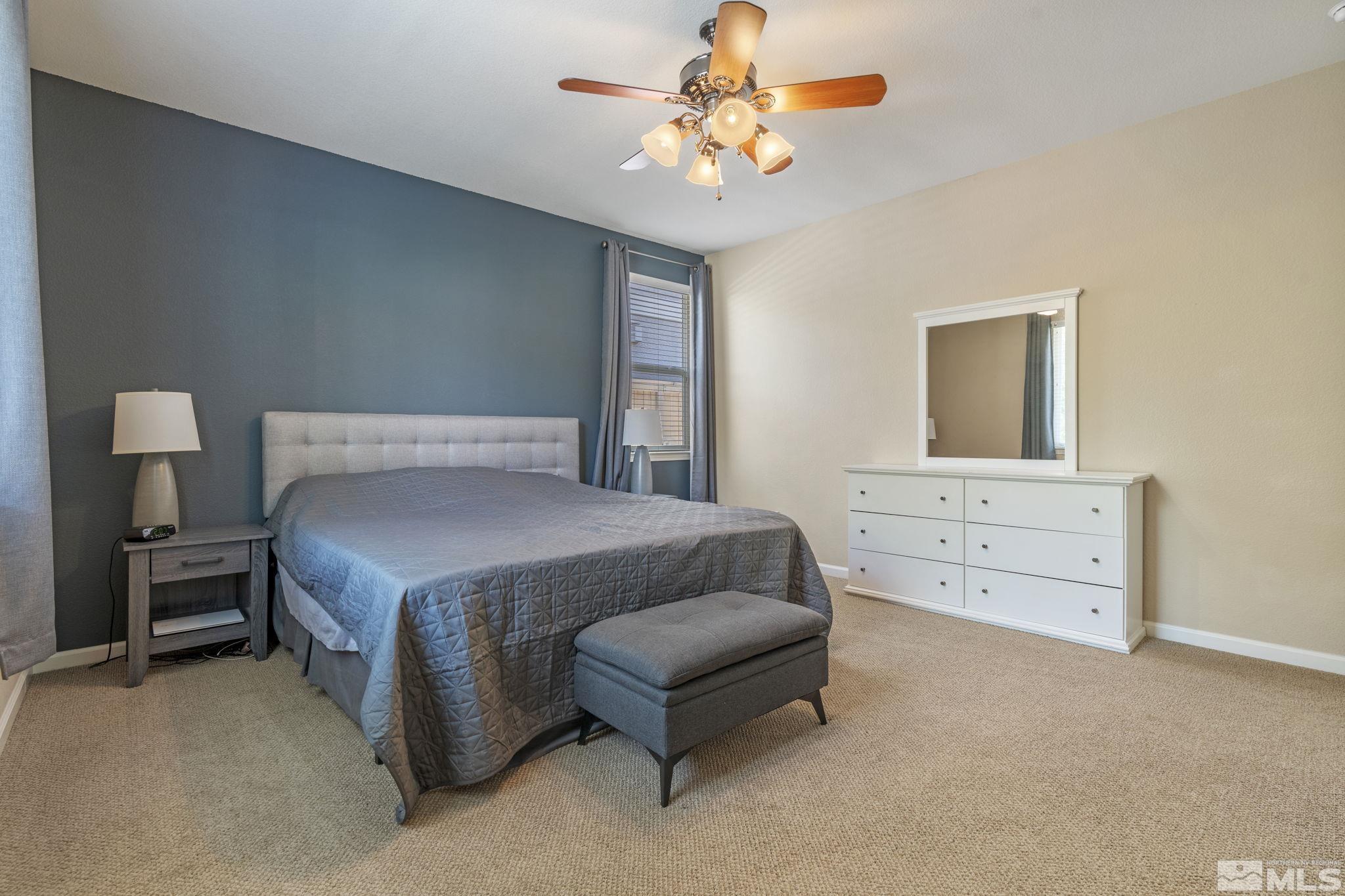10848 Oakhaven Drive Reno, NV 89521 - Photo 20 of 32 a bedroom with a bed and a chandelier