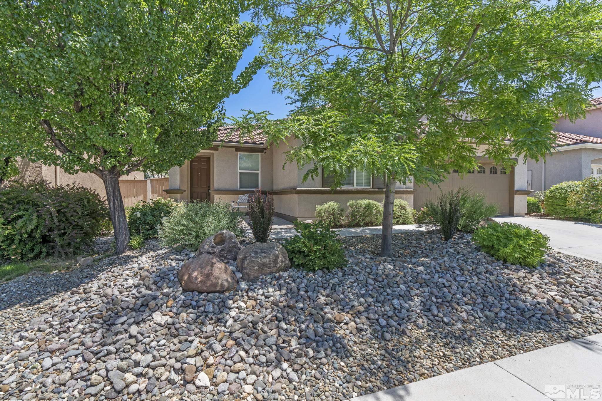 10848 Oakhaven Drive Reno, NV 89521 - Photo 3 of 32 a backyard of a house with plants and large trees