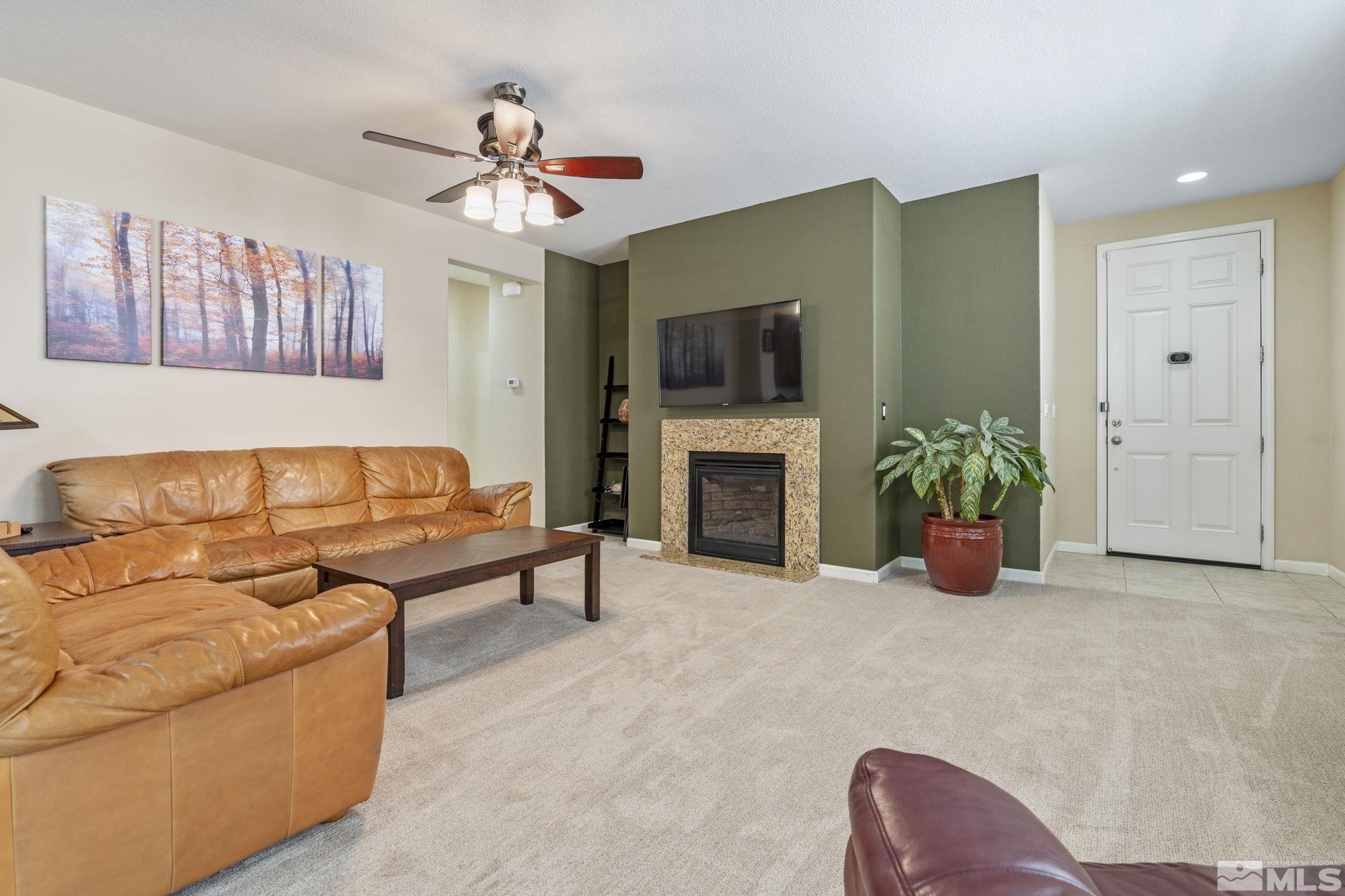 10848 Oakhaven Drive Reno, NV 89521 - Photo 7 of 32 a living room with furniture a fireplace and a flat screen tv