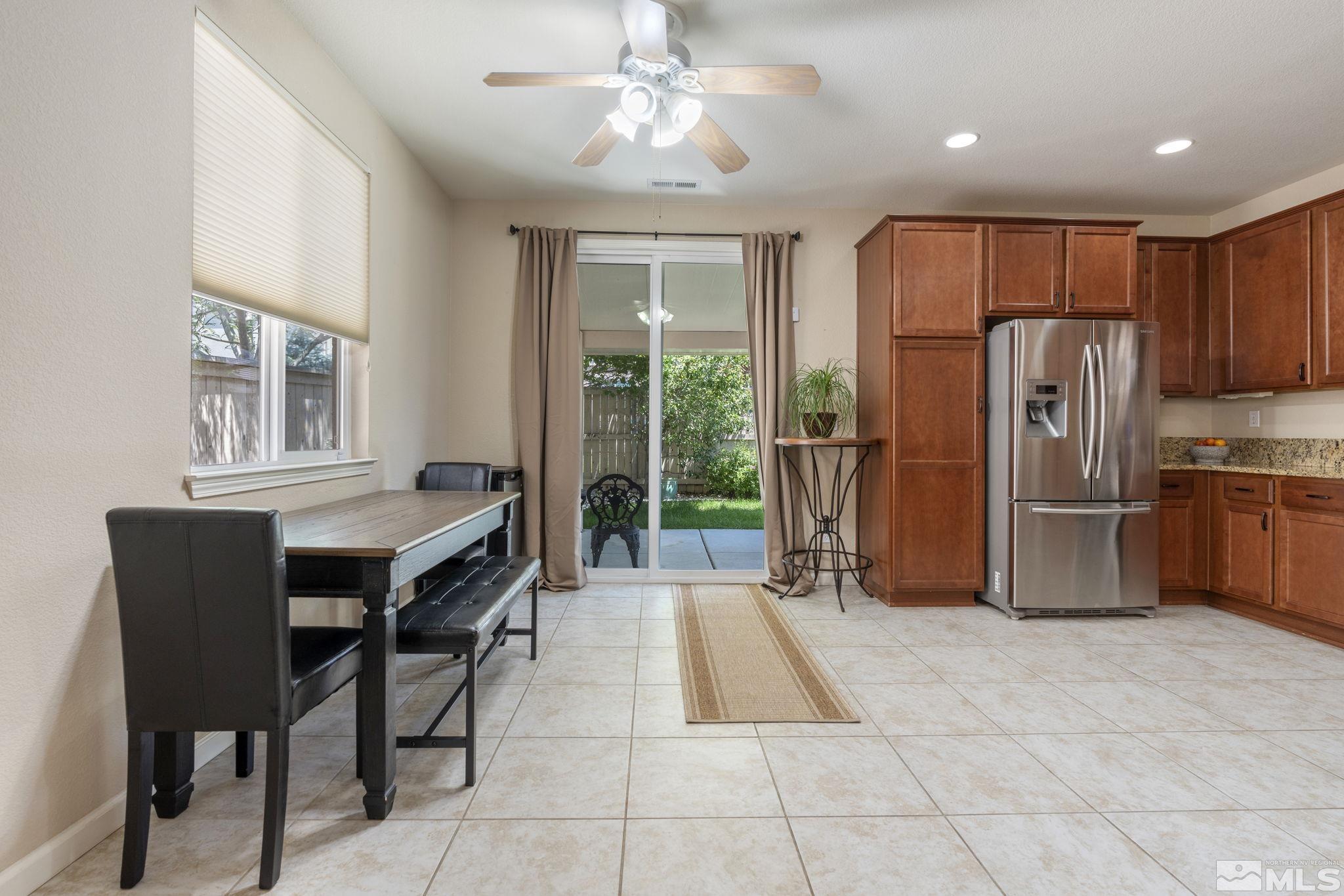 10848 Oakhaven Drive Reno, NV 89521 - Photo 8 of 32 a kitchen with stainless steel appliances granite countertop a table chairs and a refrigerator