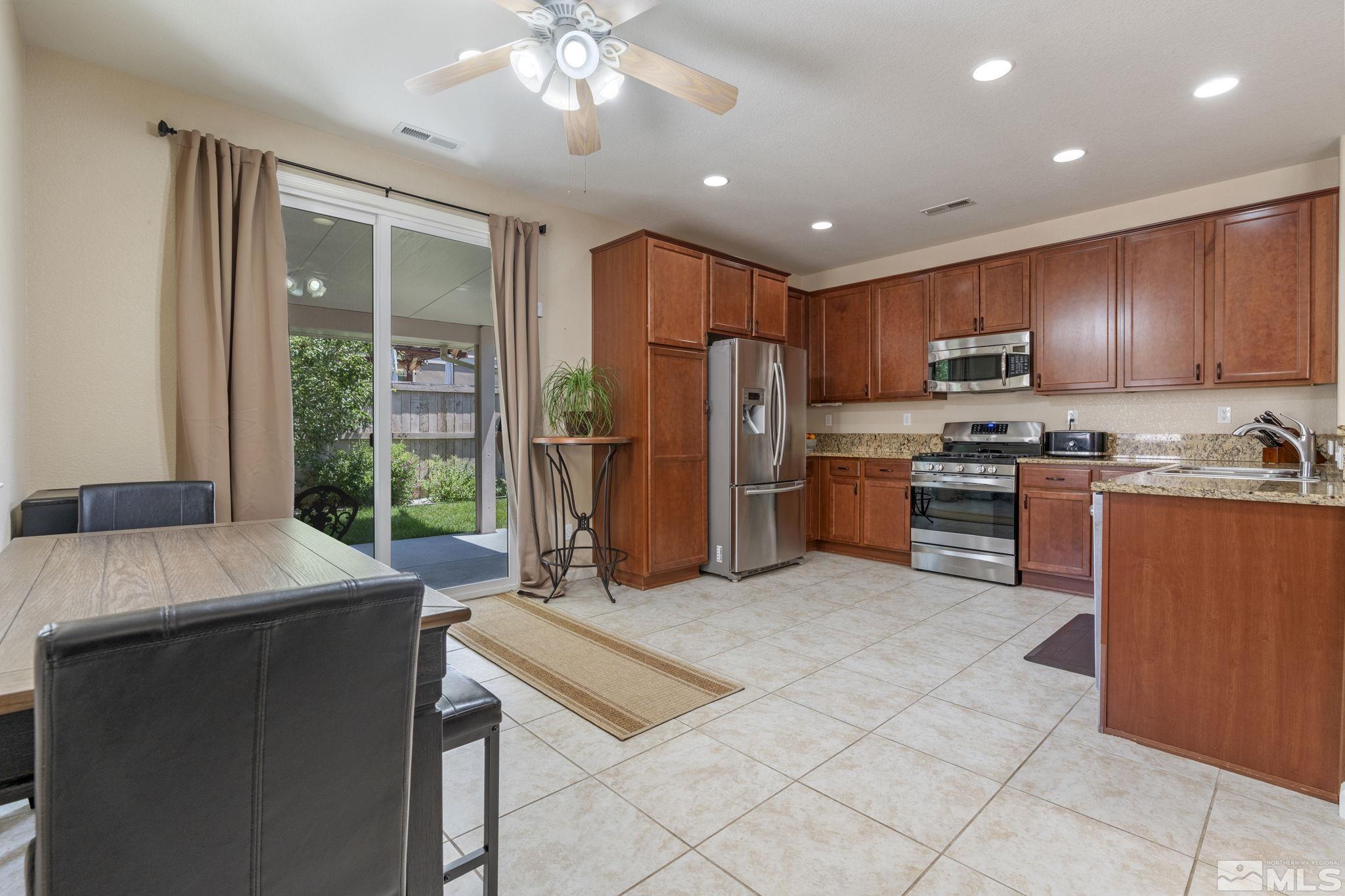 10848 Oakhaven Drive Reno, NV 89521 - Photo 10 of 32 a kitchen with stainless steel appliances granite countertop a refrigerator a sink dishwasher a stove with open kitchen view