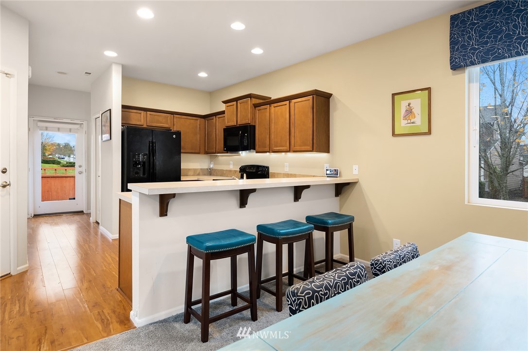 4738 Court R Tacoma, WA 98404 - Photo 13 of 32 a kitchen with stainless steel appliances kitchen island a table chairs in it and wooden floors