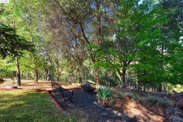 a view of a backyard with table and chairs under an umbrella