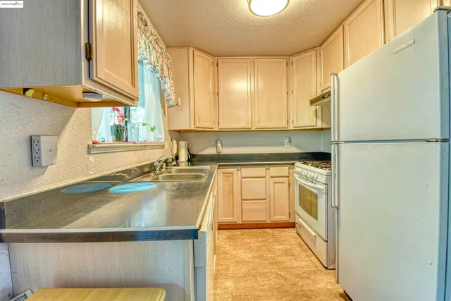 a kitchen with a refrigerator a stove top oven and a sink
