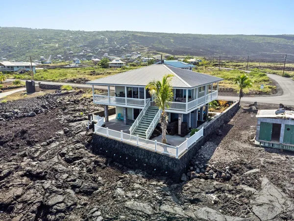 an aerial view of a house with a garden and lake view