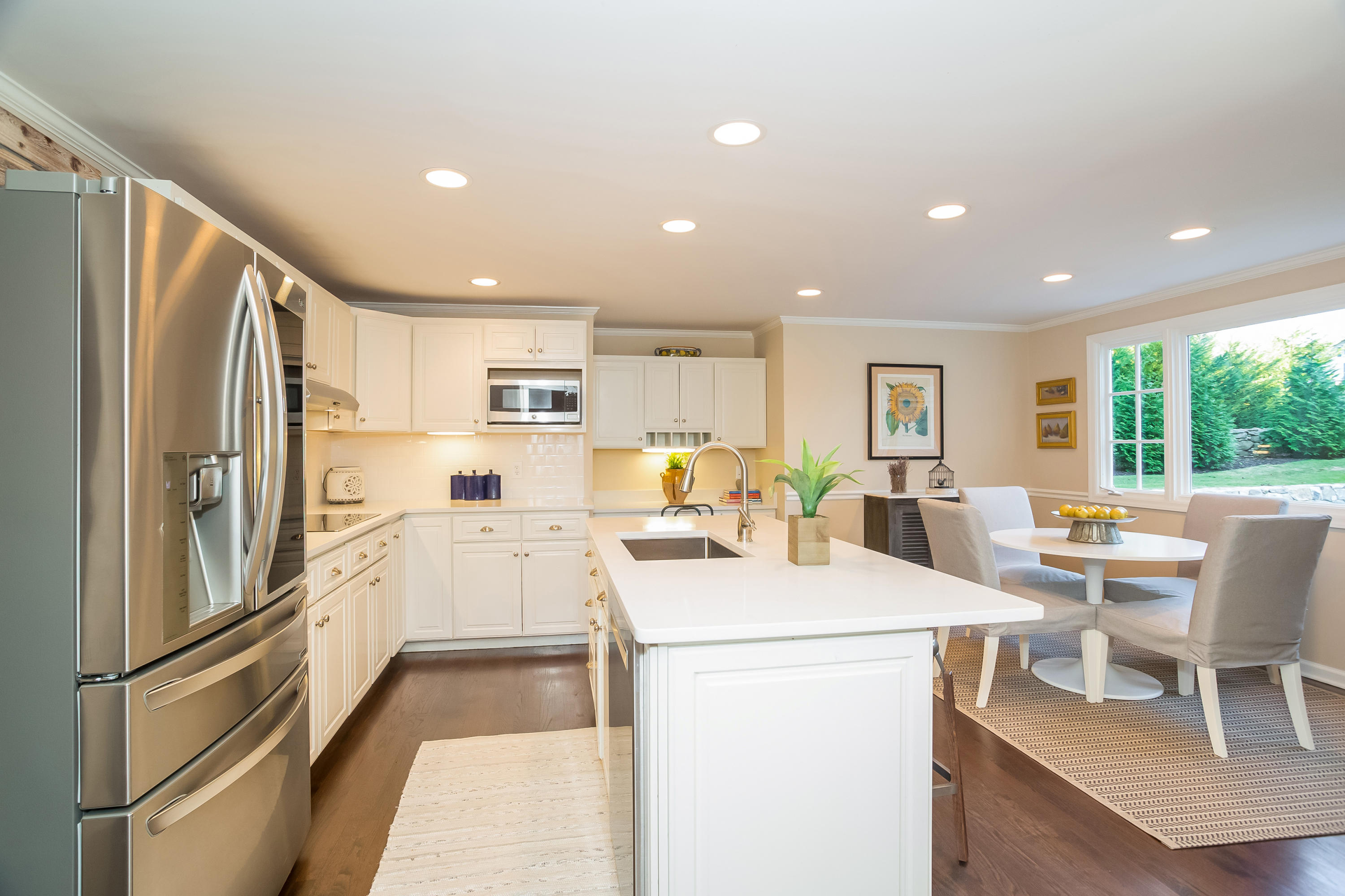 23 Rocaton Road Darien, CT 06820 - Photo 5 of 36 a kitchen with a refrigerator a stove and a dining table with wooden floor