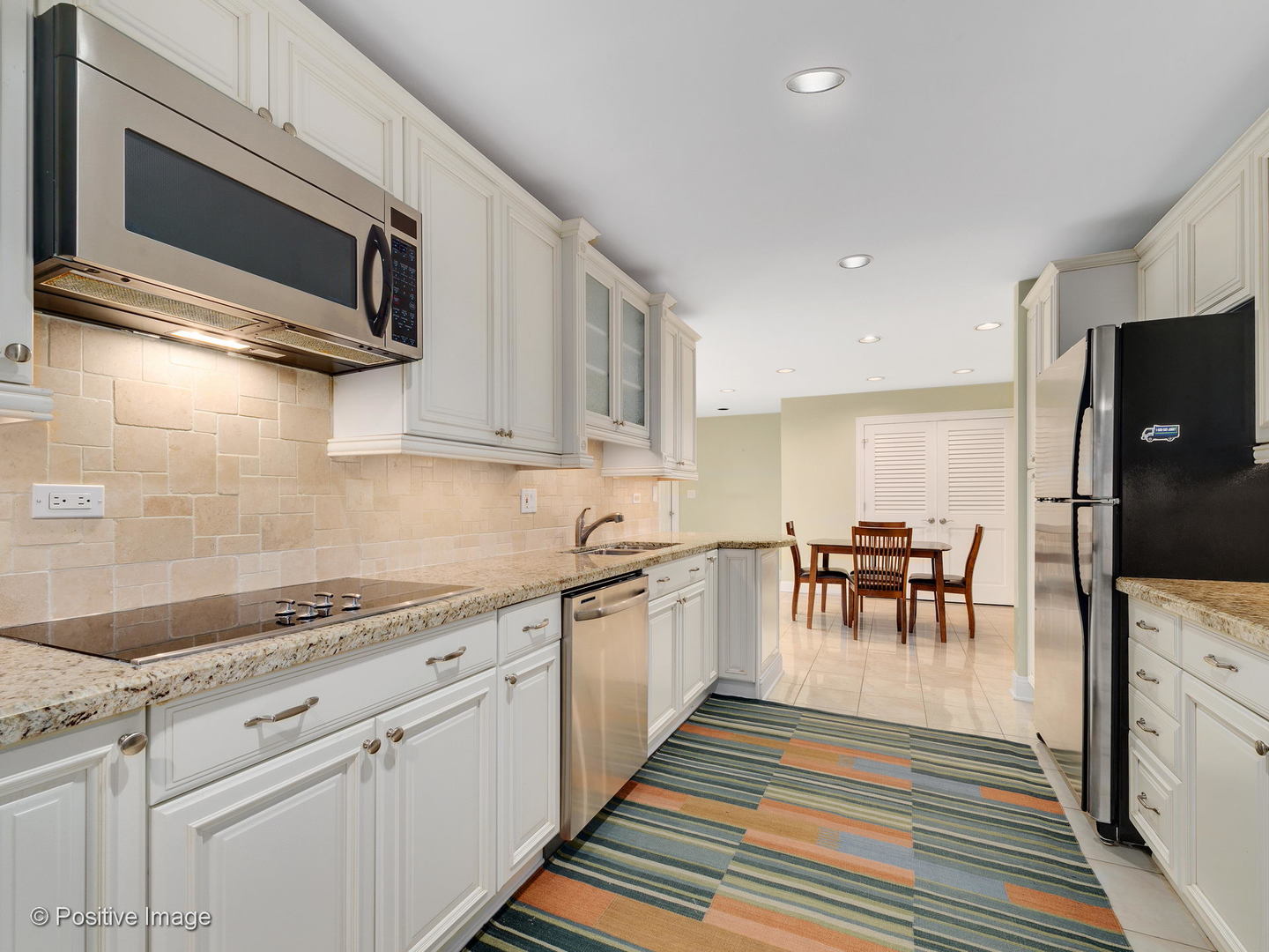 1228 Indian Trail Road Hinsdale, IL 60521 - Photo 9 of 27 a kitchen with stainless steel appliances granite countertop a stove a sink and a microwave