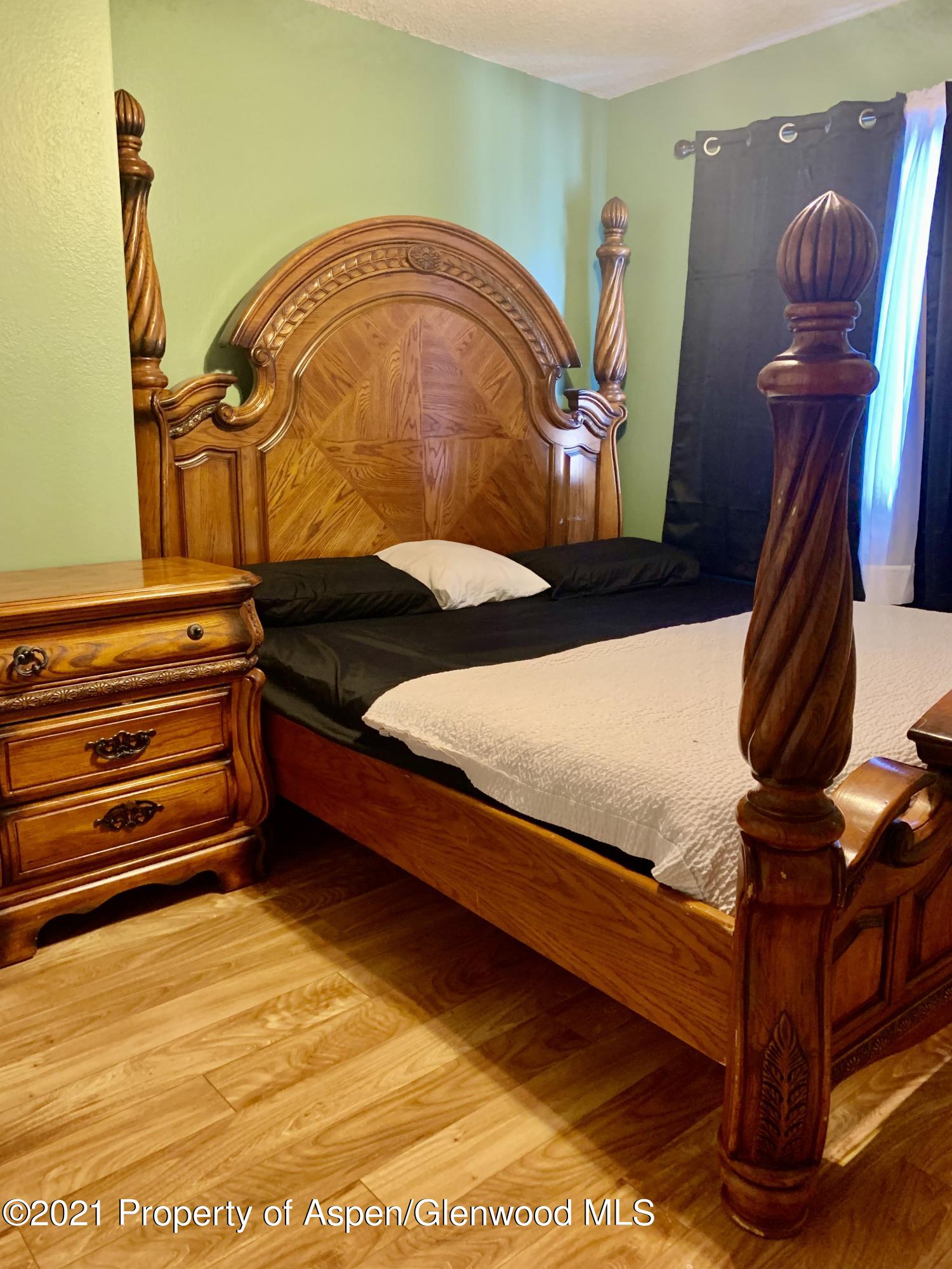 615 Ash Avenue Rifle, CO 81650 - Photo 14 of 24 a bedroom with a bed and wooden floor