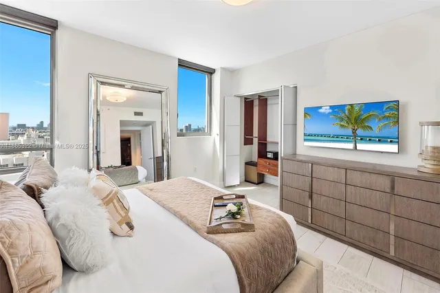 a bedroom with a bed and a flat screen tv