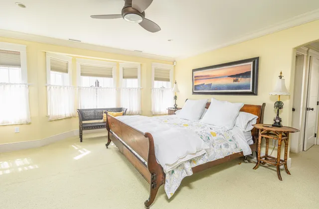 a bed sitting in a spacious bedroom next to a window