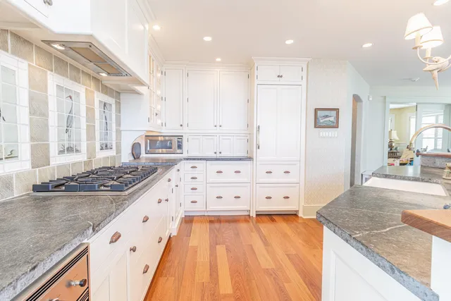 a large kitchen with kitchen island a sink stainless steel appliances and cabinets