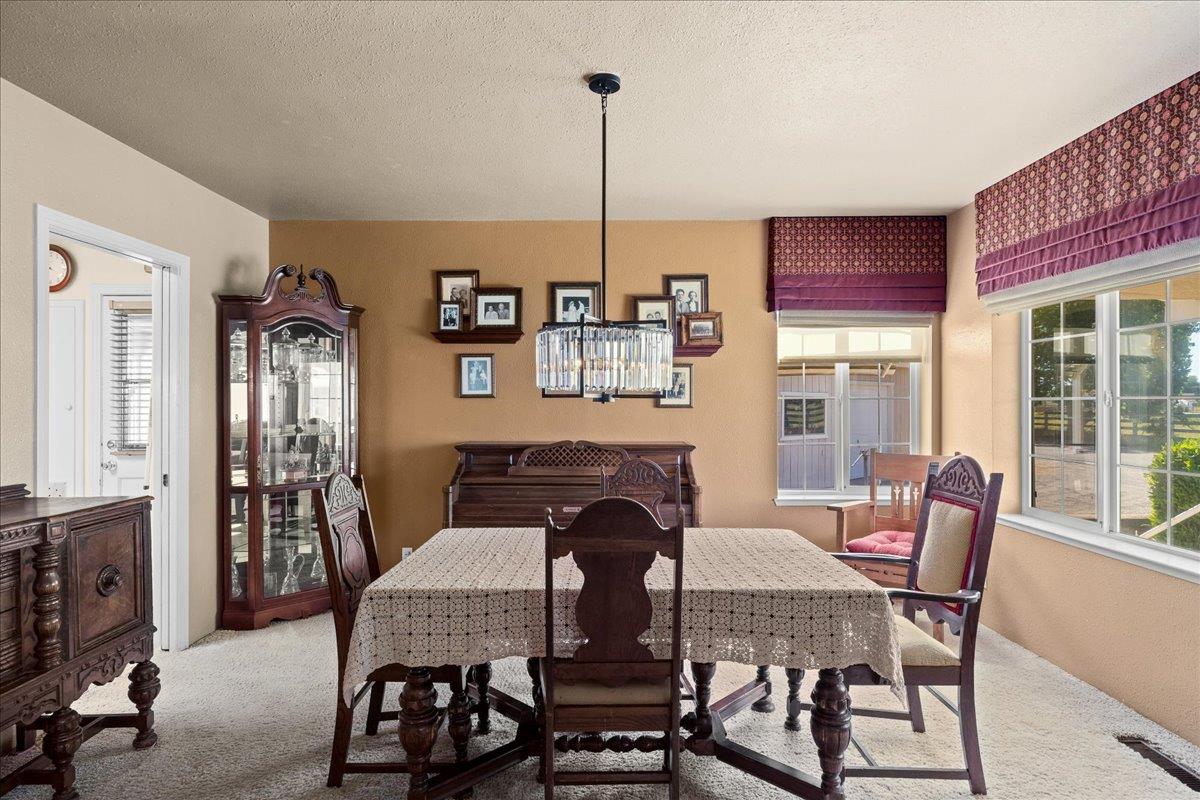 4701 Lone Tree Road Valley Home, CA 95361 - Photo 15 of 59 a view of a dining room with furniture and chandelier