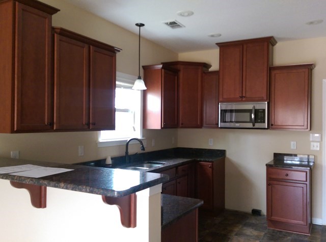 9417 Yarbrough Road Midland, GA 31820 - Photo 3 of 8 a kitchen with granite countertop a sink a stove and refrigerator