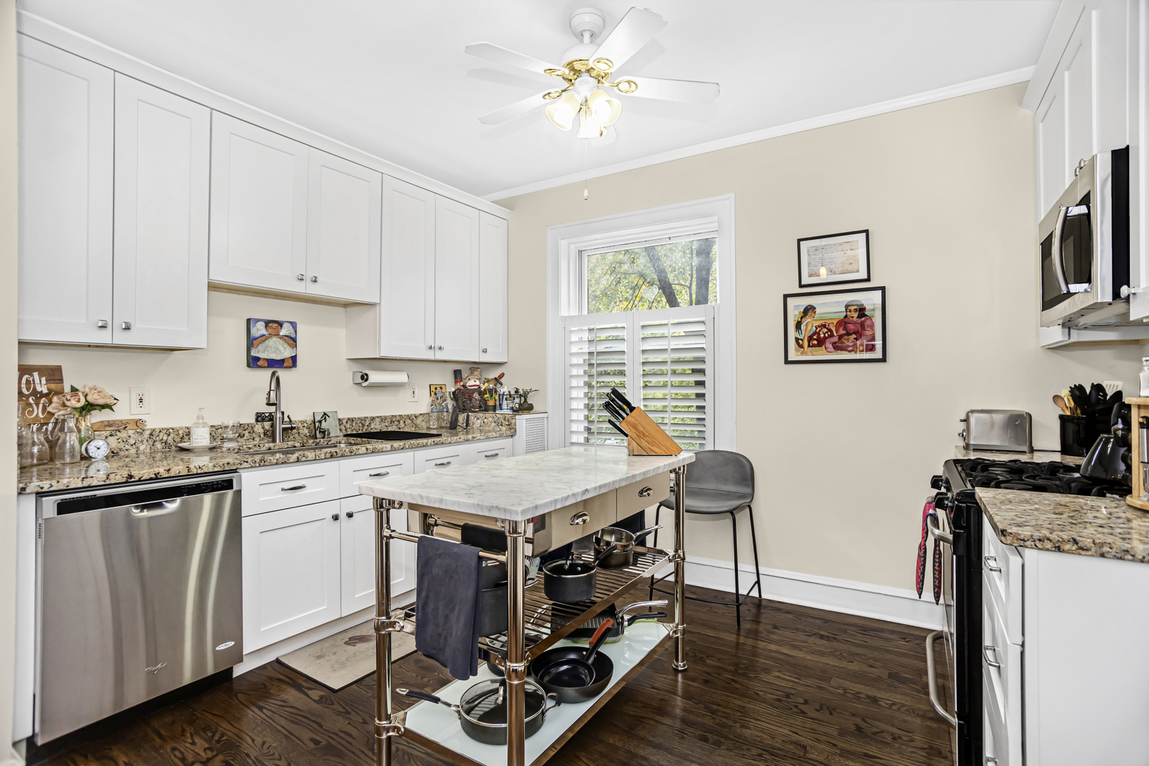 520 Sheridan Road, Unit 2A Evanston, IL 60202 - Photo 8 of 16 a kitchen with granite countertop a stove a sink a dining table and chairs with wooden floor