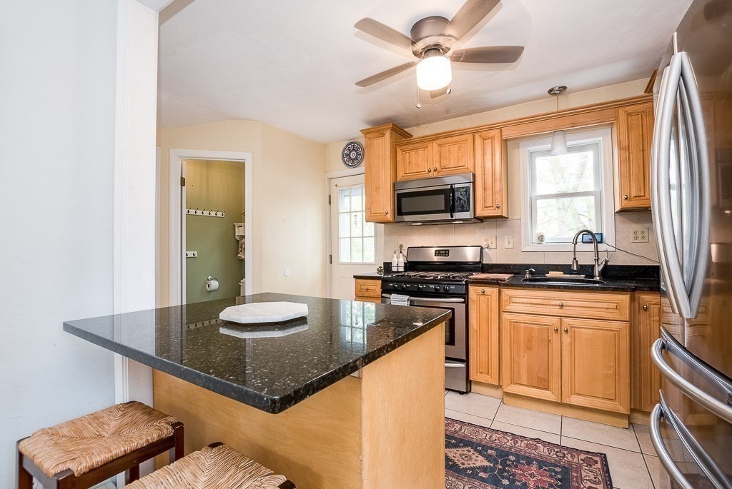 217 Lawrence Street Canton, MA 02021 - Photo 7 of 34 a kitchen with stainless steel appliances granite countertop a stove a sink and a microwave