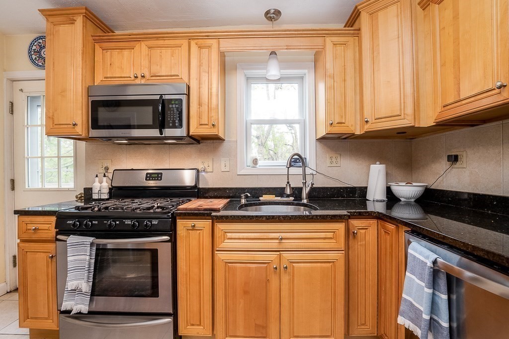 217 Lawrence Street Canton, MA 02021 - Photo 8 of 34 a kitchen with stainless steel appliances granite countertop a stove a sink and a microwave