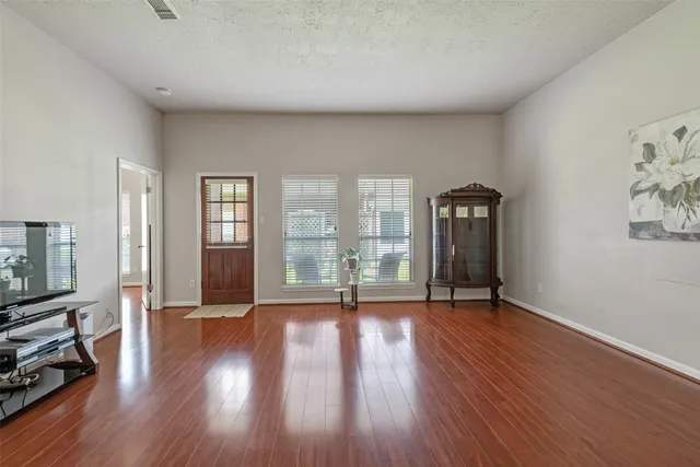 a view of a livingroom with furniture wooden floor and windows