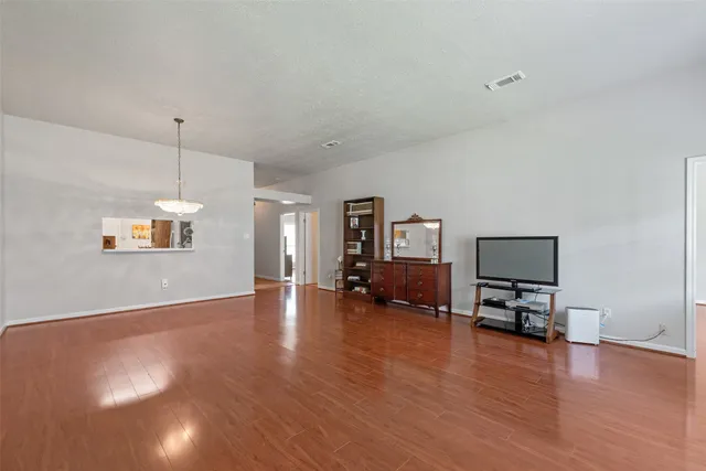 a view of empty room with wooden floor