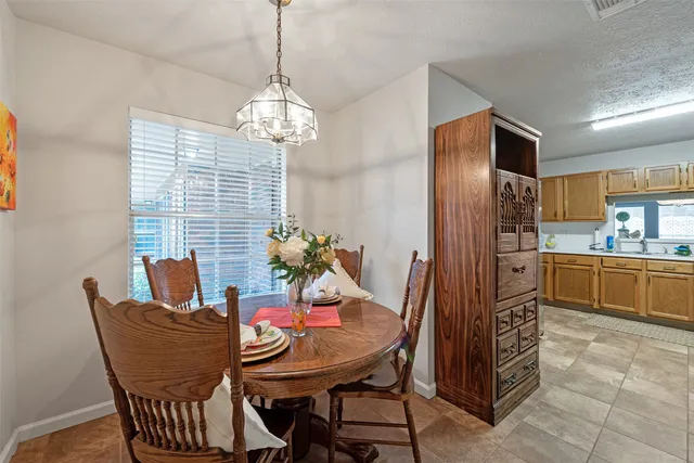 a view of a dining room with furniture a chandelier and window