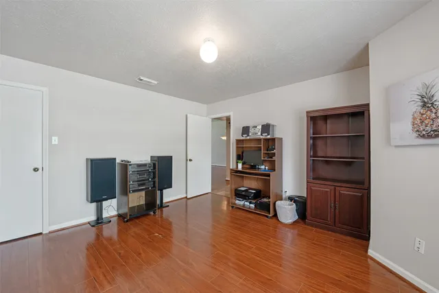an empty room with piano and wooden floor