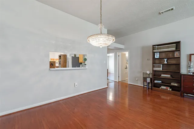a view of a room with wooden floor and ceiling fan