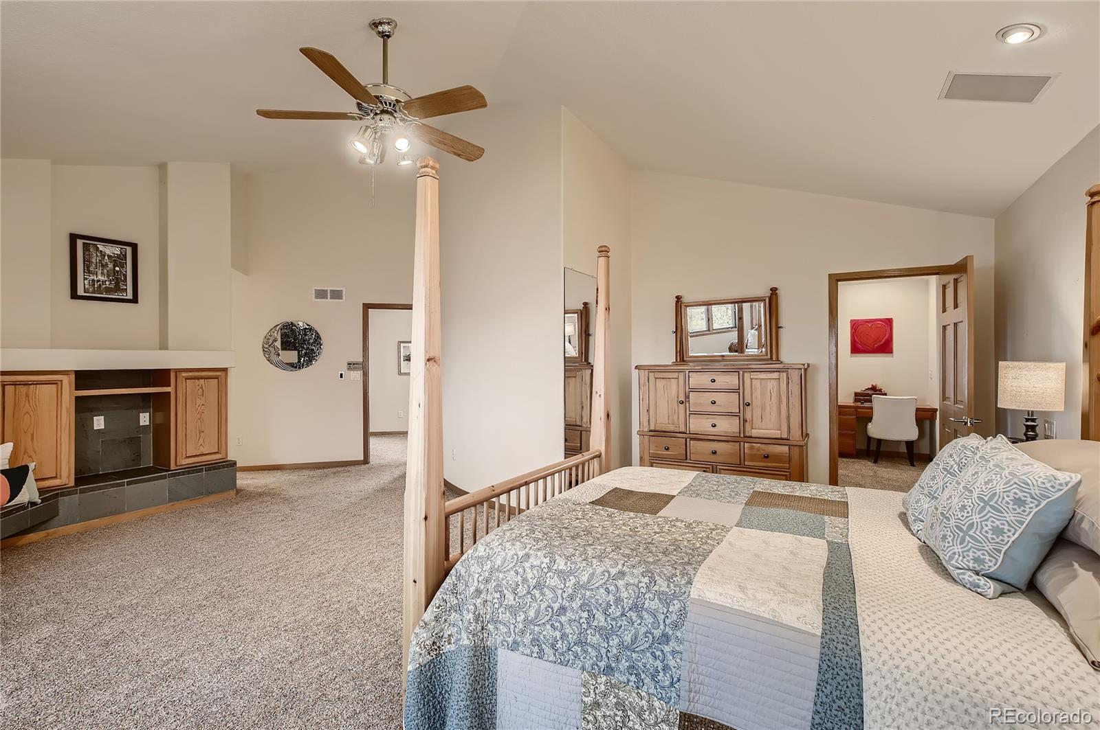 7748 Crestview Lane Niwot, CO 80504 - Photo 21 of 40 a spacious bedroom with a bed and a chandelier