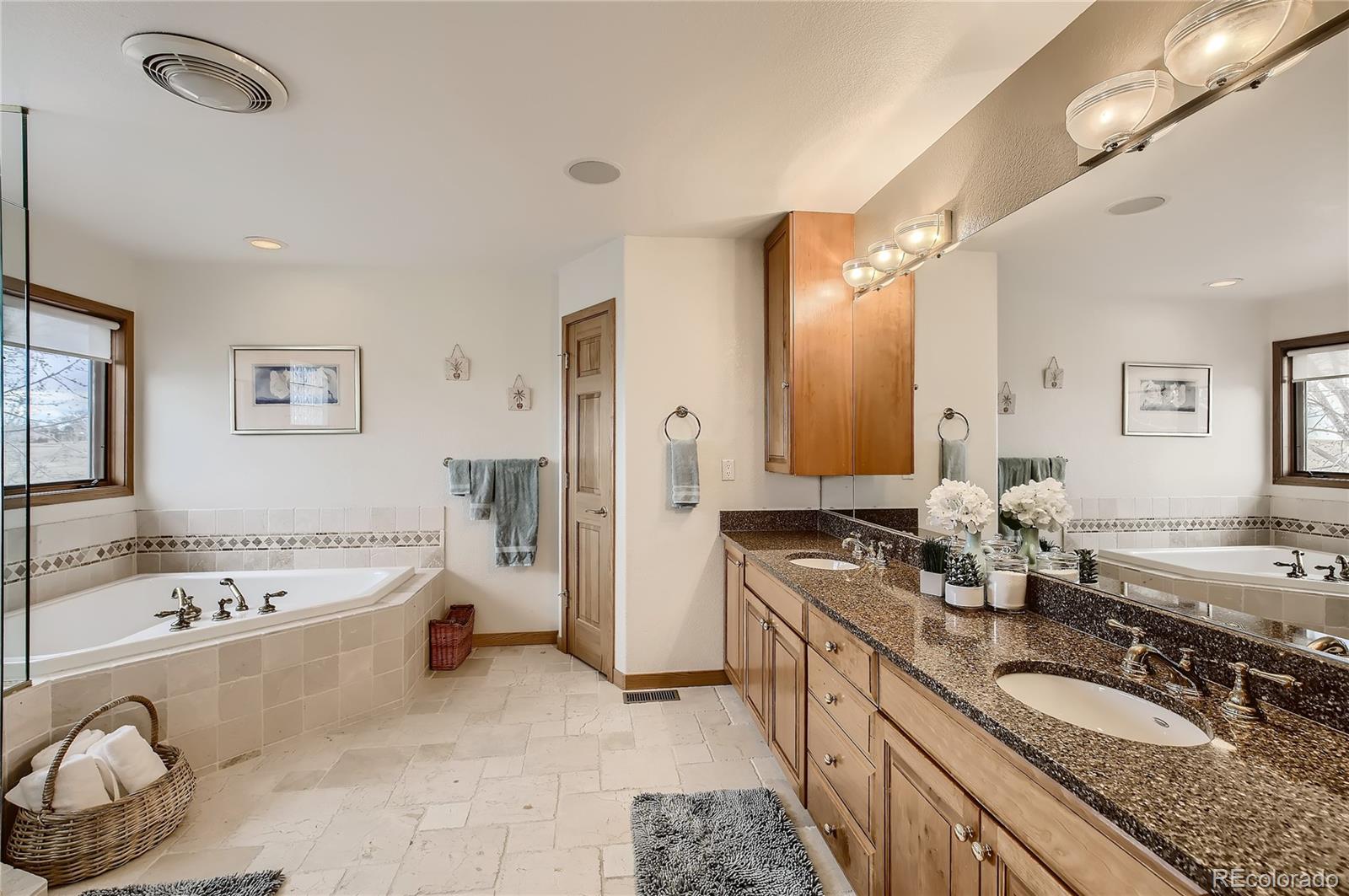 7748 Crestview Lane Niwot, CO 80504 - Photo 23 of 40 a spacious bathroom with a granite countertop tub sink and mirror