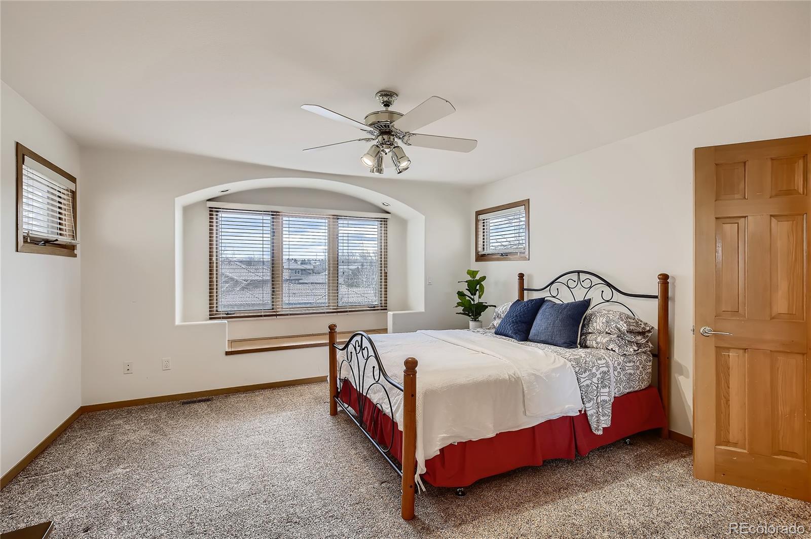 7748 Crestview Lane Niwot, CO 80504 - Photo 27 of 40 a bedroom with a bed lamp and a large window