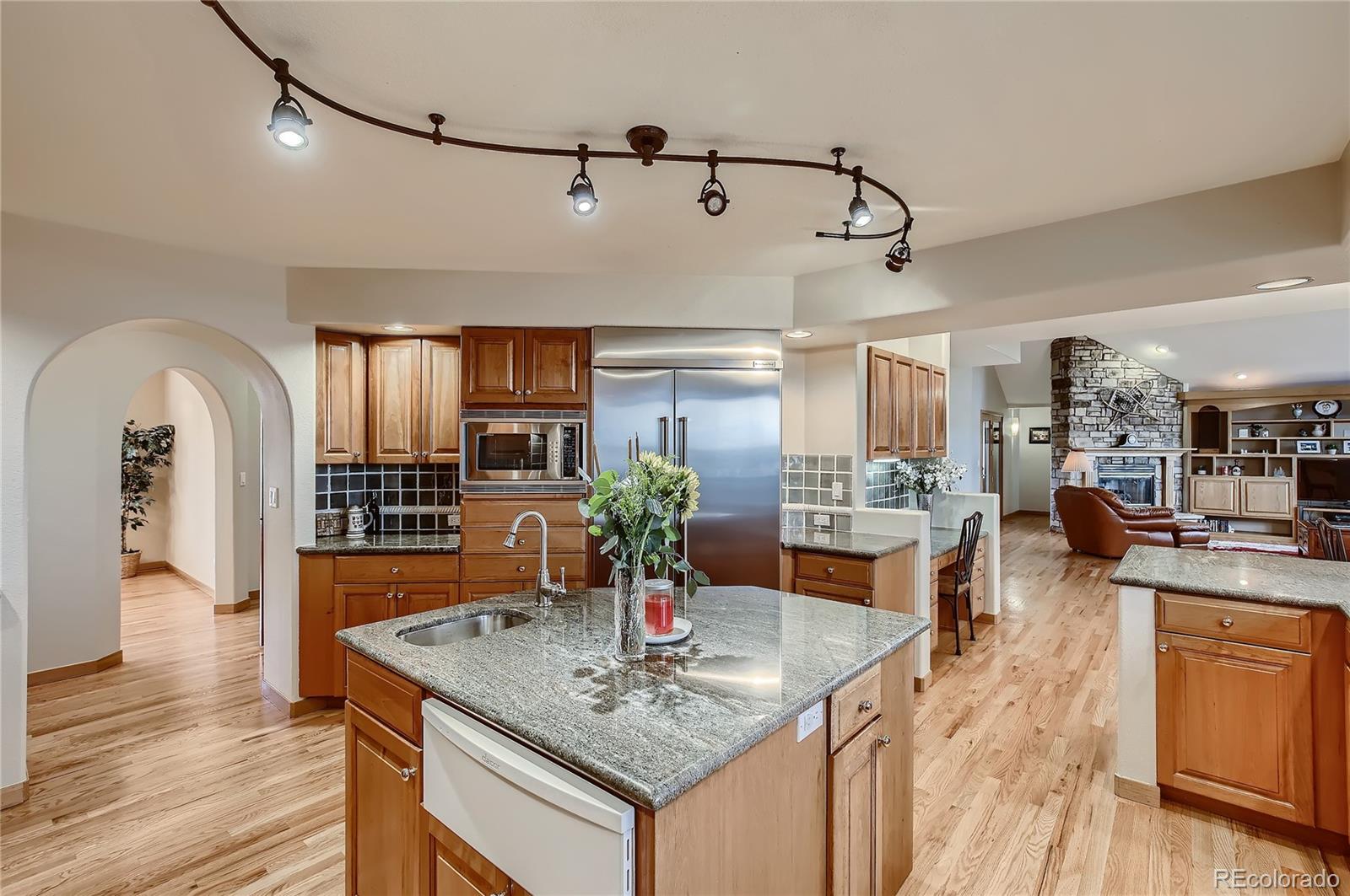 7748 Crestview Lane Niwot, CO 80504 - Photo 7 of 40 a view of kitchen island with stainless steel appliances granite countertop center island wooden floor and living room view