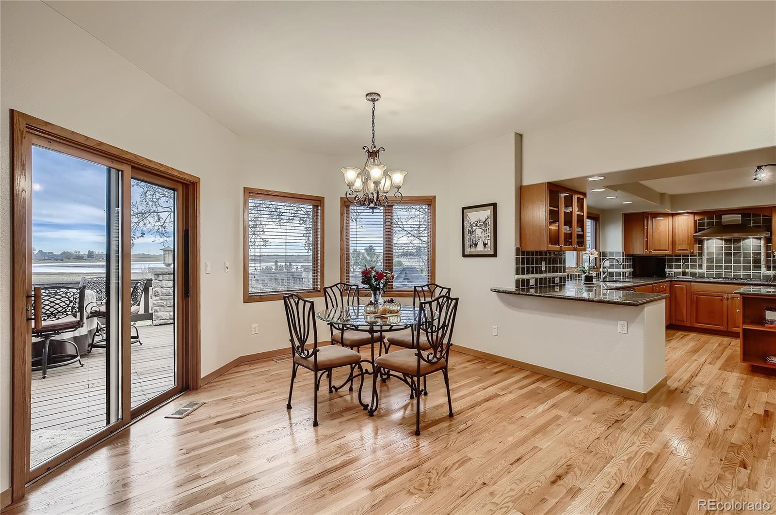 7748 Crestview Lane Niwot, CO 80504 - Photo 9 of 40 a dining room with wooden floor a chandelier a wooden table and chairs