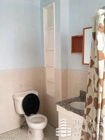 a bathroom with a granite countertop toilet and a sink
