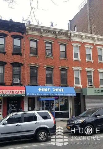a front view of a building and car parked