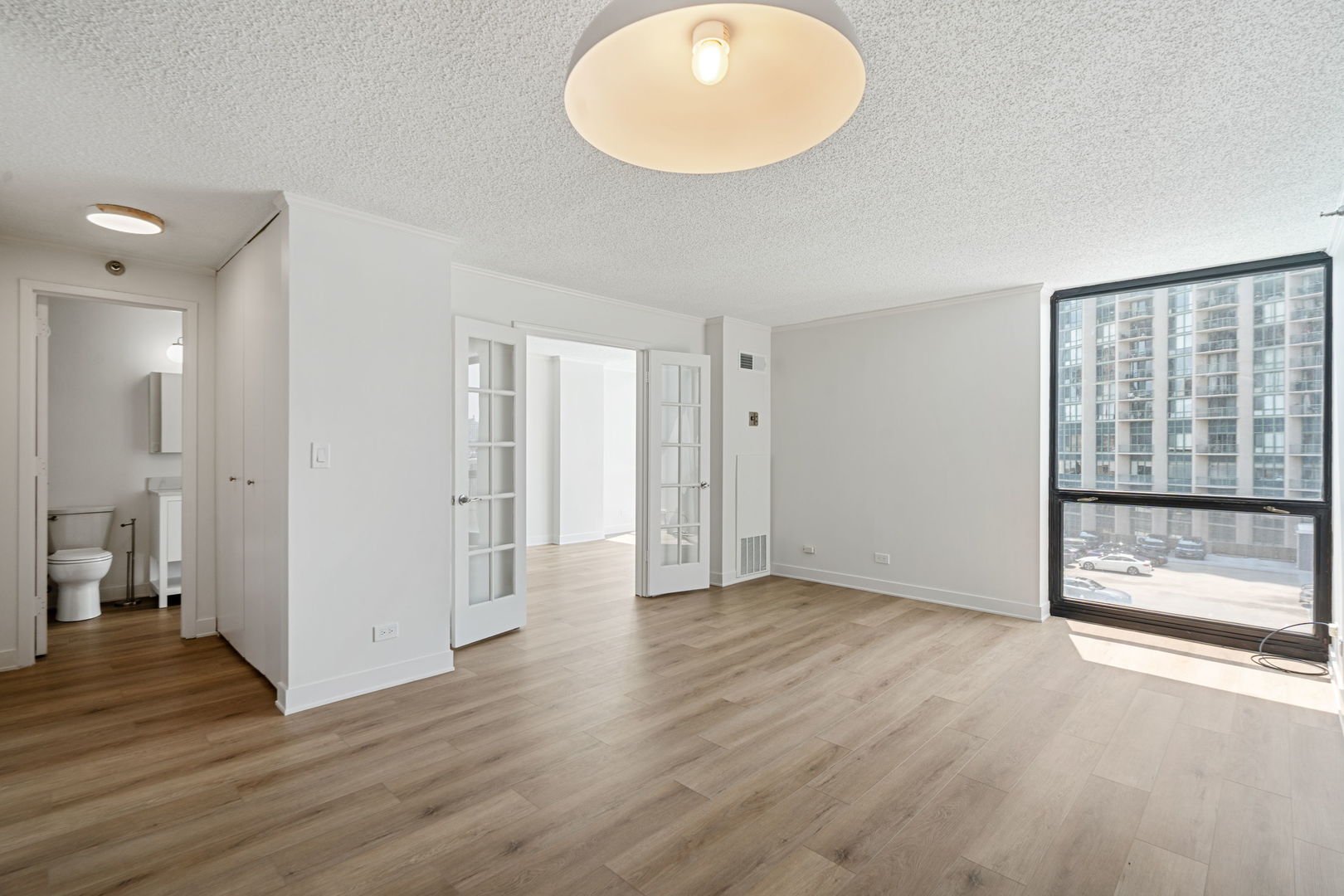 1122 North Clark Street, Unit 1010 Chicago, IL 60610 - Photo 3 of 21 wooden floor in an empty room with a window