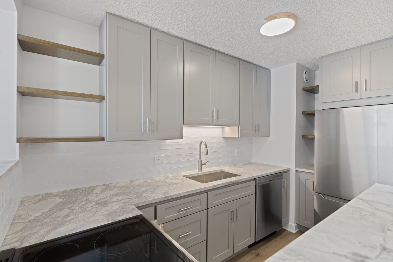1122 North Clark Street, Unit 1010 Chicago, IL 60610 - Photo 8 of 21 a kitchen with stainless steel appliances granite countertop a sink stove and refrigerator