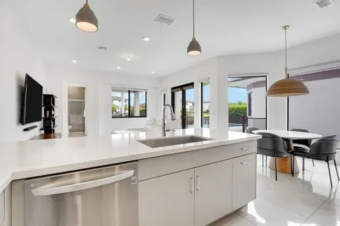 a kitchen with stainless steel appliances granite countertop a sink and a refrigerator